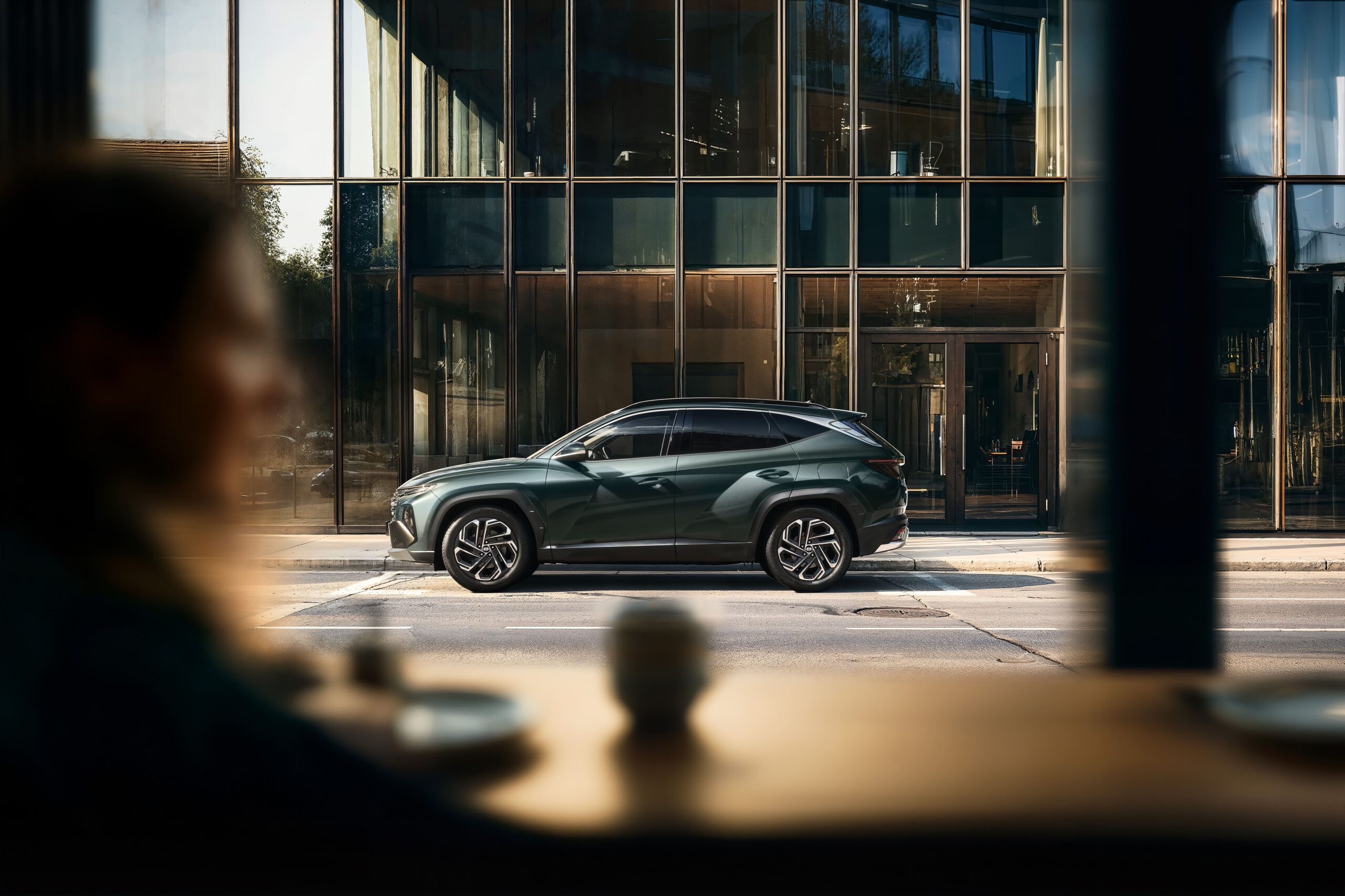 Nešteto vprašanj, en sam odgovor! Hyundai Tucson 1 Hyundai Tucson parkiran pred moderno arhitekturo v mestu