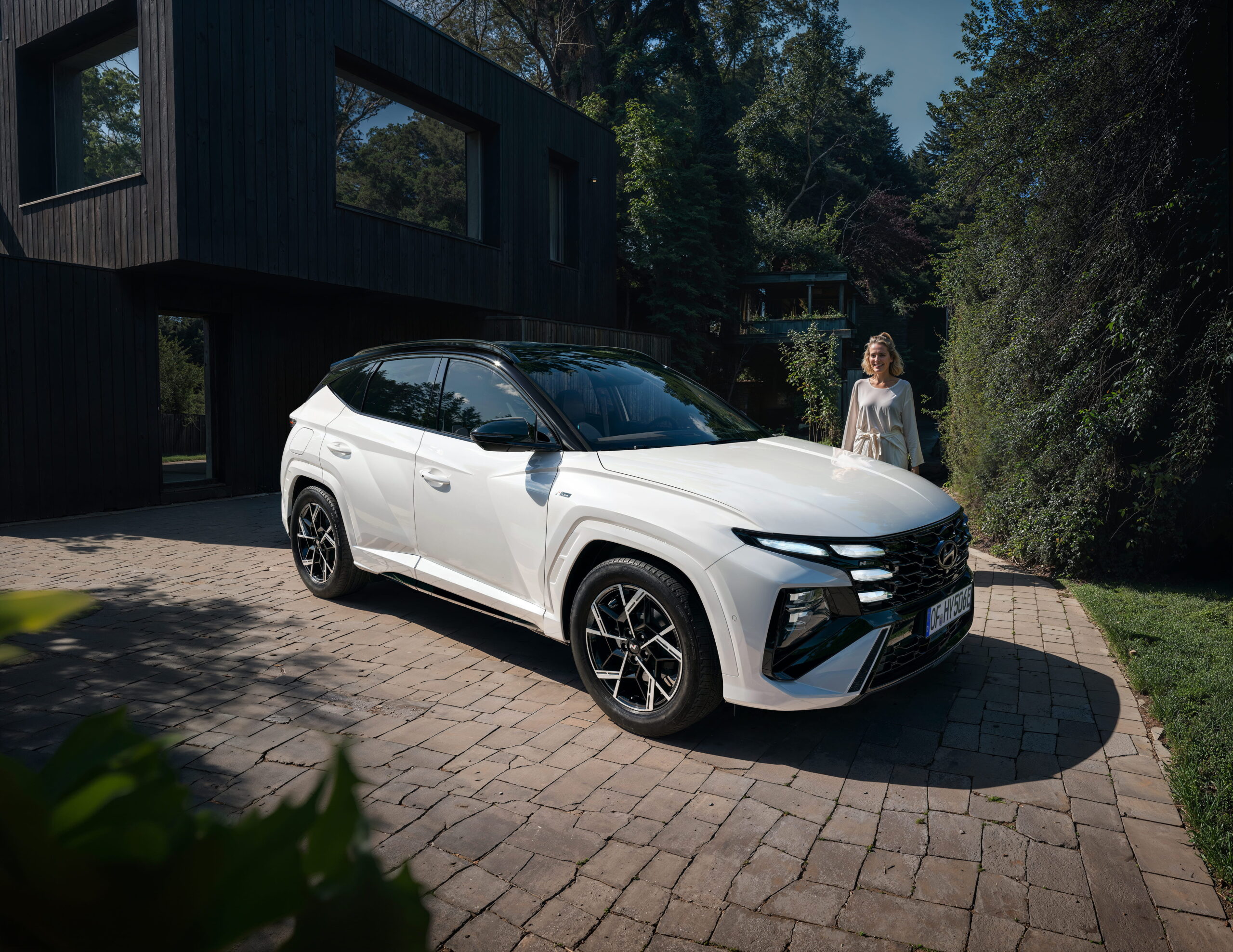 Nešteto vprašanj, en sam odgovor! Hyundai Tucson 4 Beli Hyundai Tucson pred moderno luksuzno hišo